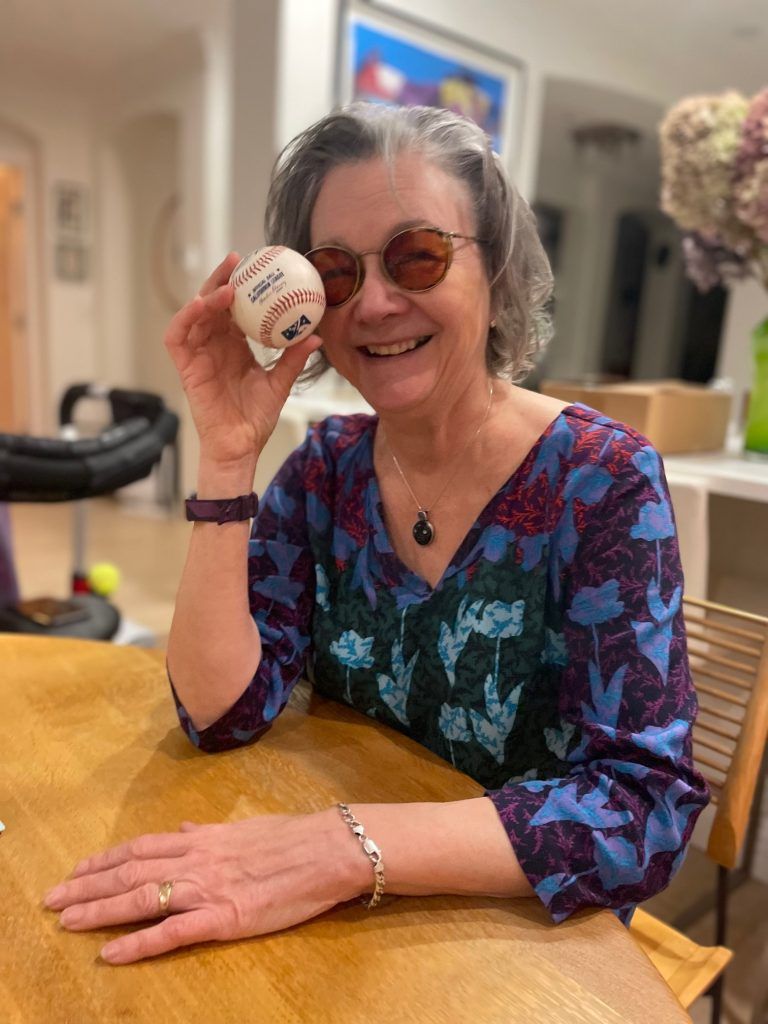 Jean Baird smiles while holding a California League Official Ball.